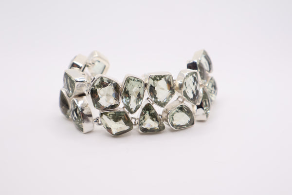 sterling silver bracelet featuring multiple green, faceted, irregularly shaped gemstone links
