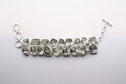 sterling silver bracelet featuring multiple green, faceted, irregularly shaped gemstone links