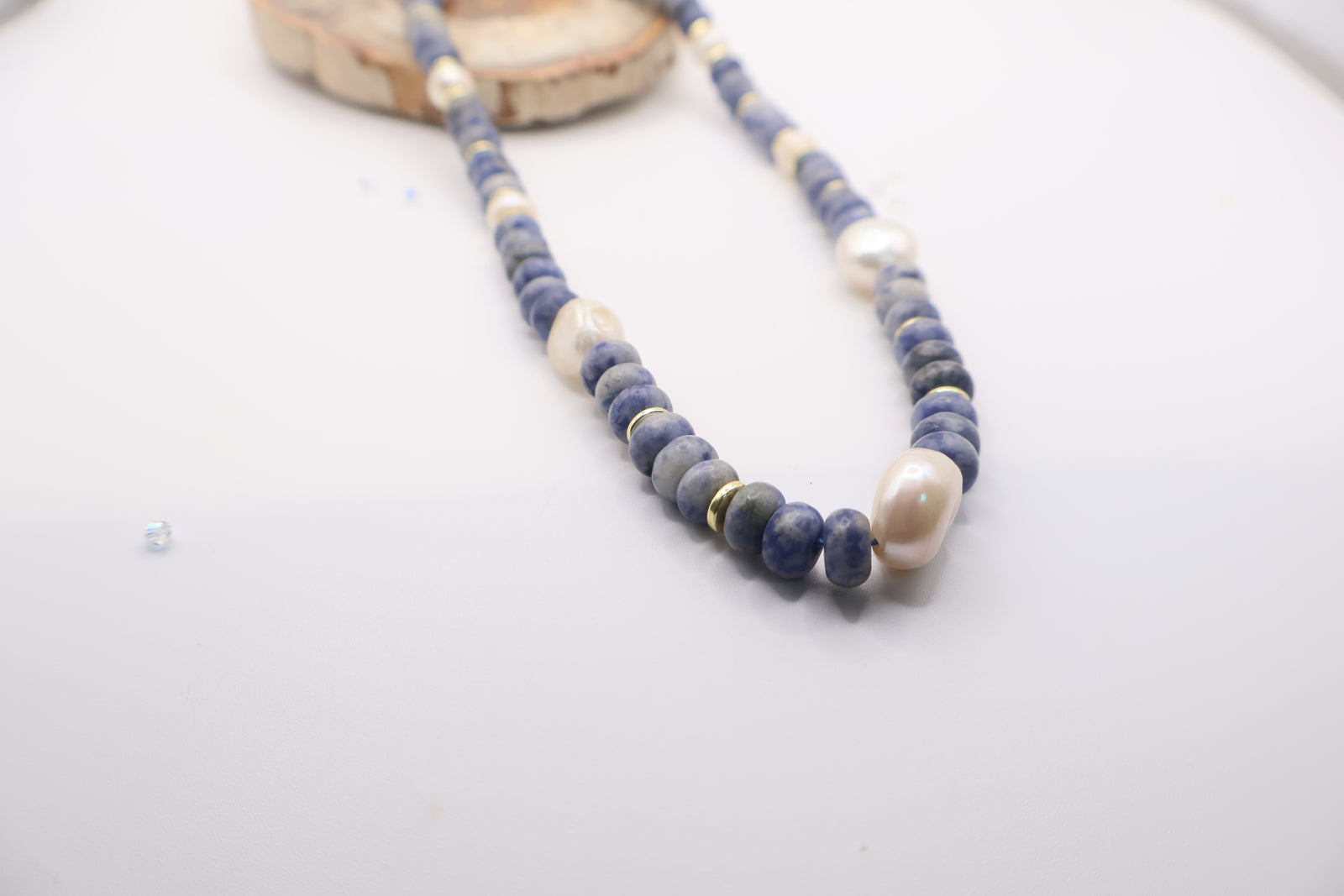 sodalite and pearl beaded necklace featuring blue gemstone beads, white freshwater pearls, and gold-colored spacer beads