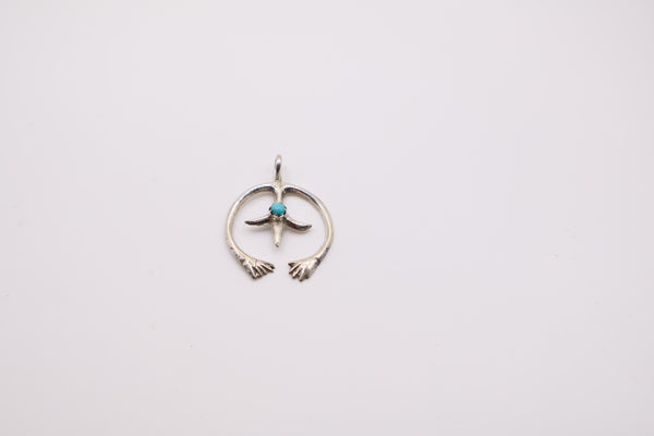 Native American Navajo sterling silver Naja pendant features a small turquoise stone at its center