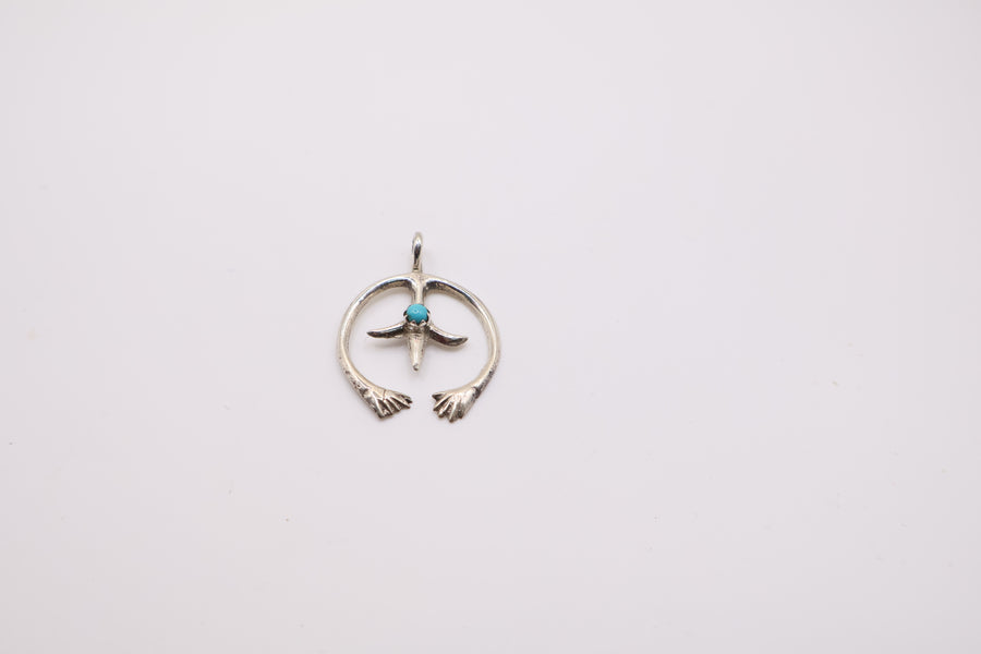 Native American Navajo sterling silver Naja pendant features a small turquoise stone at its center