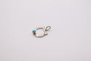 Native American sterling silver horseshoe pendant features a centered turquoise stone and often resembles handcrafted Navajo designs