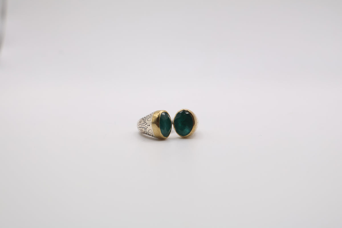 Sterling silver two-tone ring features a smooth oval green gemstone ring